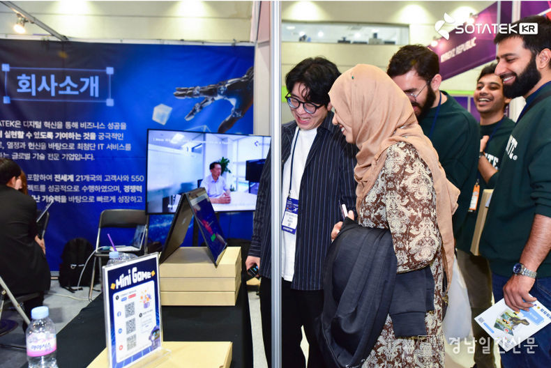 2025 WIS 박람회에서 한국인 엔지니어 팀원이 부스 퀴즈를 진행하며 외국인 참관객들과 소통하는 모습